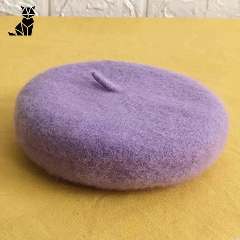 Élégant chapeau violet pour chat sur une table - Stylish Beret Hat for Cats